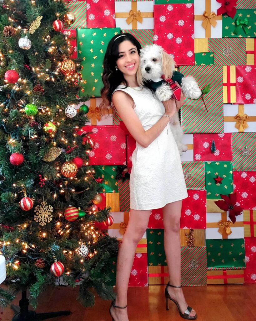 analy standing infront of a christmas backdrop wall of decorative christmas boxes